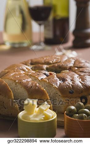 Close-up of a loaf of bread with cups of butter and olives View Large Photo Image Picture - Close-up of a loaf of bread with cups of butter and olives. Fotosearch