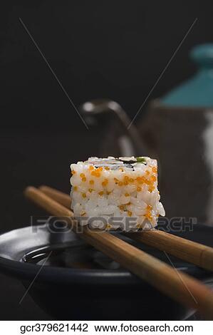 Close-up of a maki sushi with chopsticks on a bowl View Large Photo Image Stock Image - Close-up of a maki sushi with chopsticks on a bowl. Fotosearch
