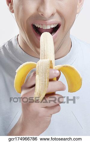 Stock Photograph - Close-up of a man eating a banana. Fotosearch