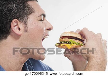 Stock Photography - Close-up of a man eating a hamburger. Fotosearch