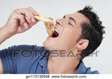 Close-up of a man eating a slice of pizza View Large Photo Image Stock Photo - Close-up of a man eating a slice of pizza. Fotosearch