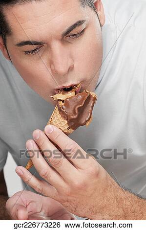 Close-up of a man eating an ice cream cone View Large Photo Image Stock Photograph - Close-up of a man eating an ice cream cone. Fotosearch