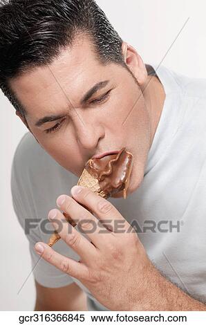 Stock Photography - Close-up of a man eating an ice cream cone. Fotosearch
