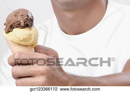 Close-up of a man holding an ice cream View Large Photo Image Stock Image - Close-up of a man holding an ice cream. Fotosearch