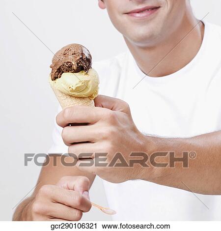 Close-up of a man holding an ice cream View Large Photo Image Stock Image - Close-up of a man holding an ice cream. Fotosearch