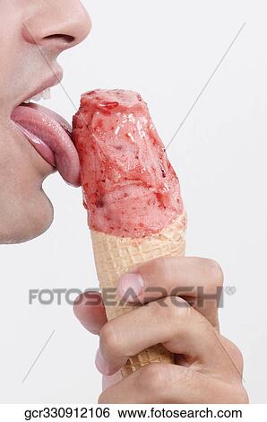Close-up of a man licking an ice cream View Large Photo Image Stock Photograph - Close-up of a man licking an ice cream. Fotosearch