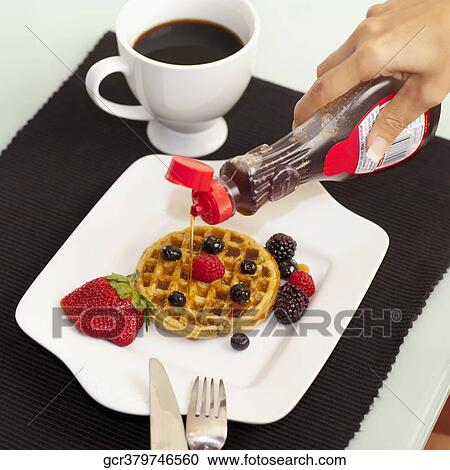 Close-up of a person pouring syrup on waffles View Large Photo Image Stock Image - Close-up of a person pouring syrup on waffles. Fotosearch