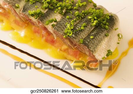 Stock Image - Close-up of a platter of fish garnished with leeks. Fotosearch