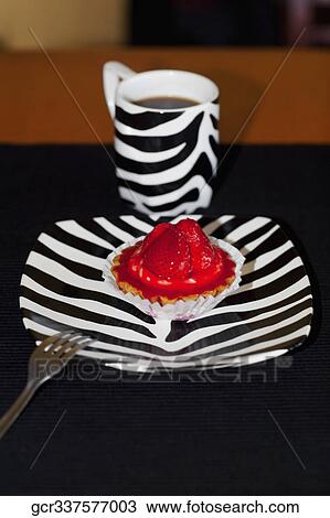 Stock Image - Close-up of a strawberry tart and a cup of coffee. Fotosearch