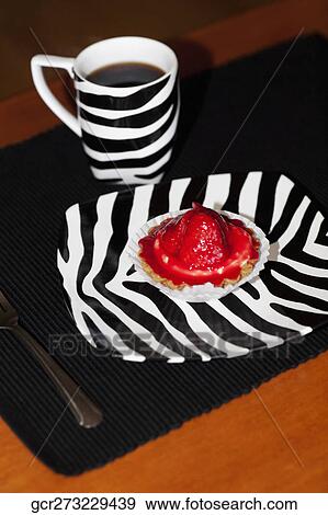 Stock Photo - Close-up of a strawberry tart and a cup of coffee. Fotosearch