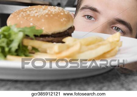 Close-up of a waiter looking at a burger View Large Photo Image Stock Image - Close-up of a waiter looking at a burger. Fotosearch