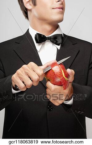 Stock Photo - Close-up of a waiter peeling an apple. Fotosearch