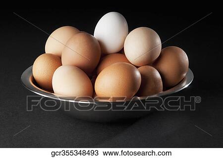 Close-up of a white egg on top of brown eggs View Large Photo Image Stock Image - Close-up of a white egg on top of brown eggs. Fotosearch