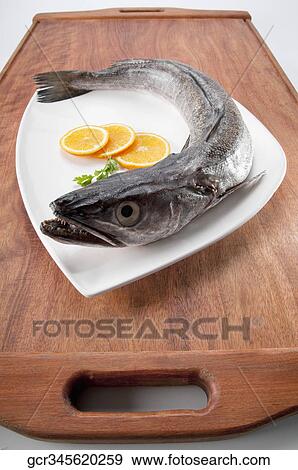 Close-up of a whole raw fish with lemon slices View Large Photo Image Stock Photo - Close-up of a whole raw fish with lemon slices. Fotosearch
