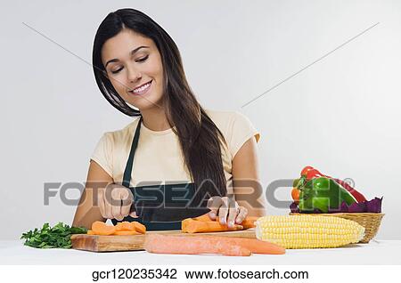 Close-up of a woman cutting vegetables View Large Photo Image Stock Image - Close-up of a woman cutting vegetables. Fotosearch