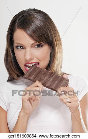 Close-up of a woman eating a bar of chocolate View Large Photo Image Picture - Close-up of a woman eating a bar of chocolate. Fotosearch