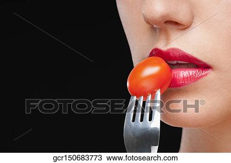 Close-up of a woman eating a cherry tomato View Large Photo Image Stock Image - Close-up of a woman eating a cherry tomato. Fotosearch