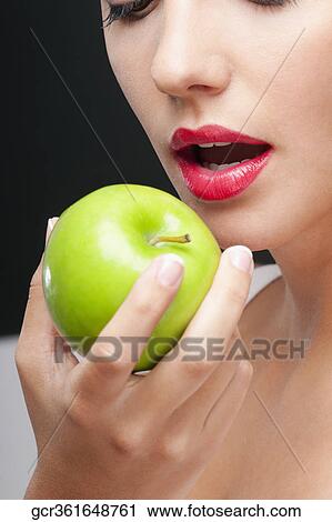 Close-up of a woman eating a granny smith apple View Large Photo Image Stock Image - Close-up of a woman eating a granny smith apple. Fotosearch