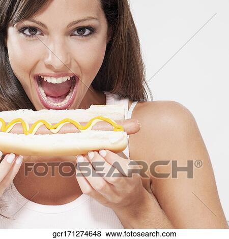 Close-up of a woman eating a hot dog View Large Photo Image Stock Photo - Close-up of a woman eating a hot dog. Fotosearch