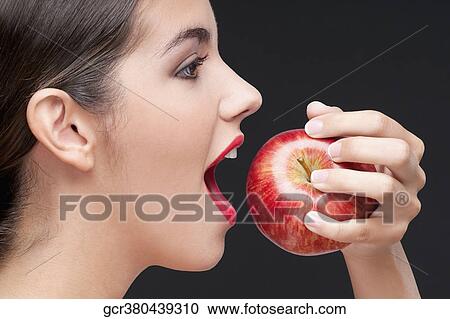 Close-up of a woman eating a red apple View Large Photo Image Stock Image - Close-up of a woman eating a red apple. Fotosearch