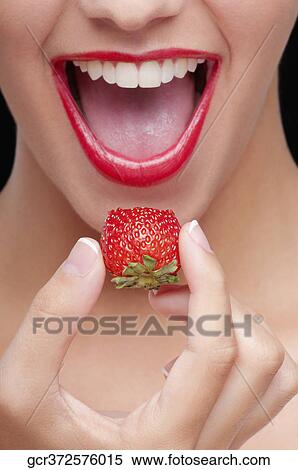 Close-up of a woman eating a strawberry View Large Photo Image Stock Photography - Close-up of a woman eating a strawberry. Fotosearch