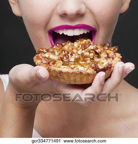 Close-up of a woman eating a tart View Large Photo Image Stock Image - Close-up of a woman eating a tart. Fotosearch