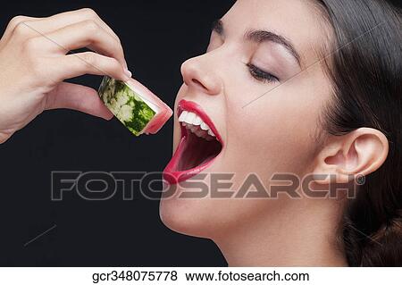Close-up of a woman eating a watermelon slice View Large Photo Image Stock Photo - Close-up of a woman eating a watermelon slice. Fotosearch