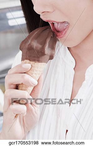 Close-up of a woman eating an ice cream View Large Photo Image Stock Photo - Close-up of a woman eating an ice cream. Fotosearch