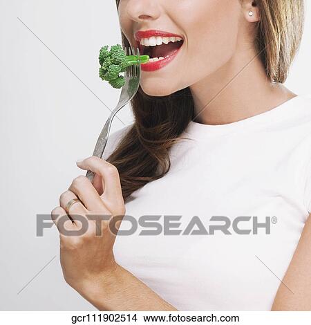 Close-up of a woman eating broccoli View Large Photo Image Picture - Close-up of a woman eating broccoli. Fotosearch