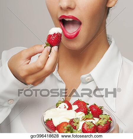 Close-up of a woman eating strawberries in cream View Large Photo Image Stock Photo - Close-up of a woman eating strawberries in cream. Fotosearch