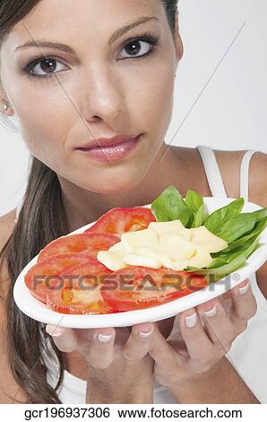 Close-up of a woman holding a basil with tomato and cheese platter View Large Photo Image Stock Photograph - Close-up of a woman holding a basil with tomato and cheese platter. Fotosearch
