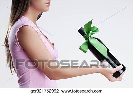 Close-up of a woman holding a bottle of wine View Large Photo Image Stock Image - Close-up of a woman holding a bottle of wine. Fotosearch