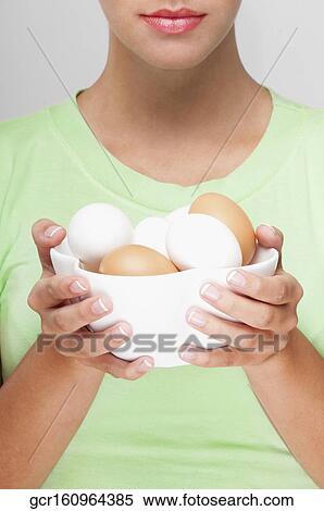 Stock Photography - Close-up of a woman holding a bowl of eggs . Fotosearch