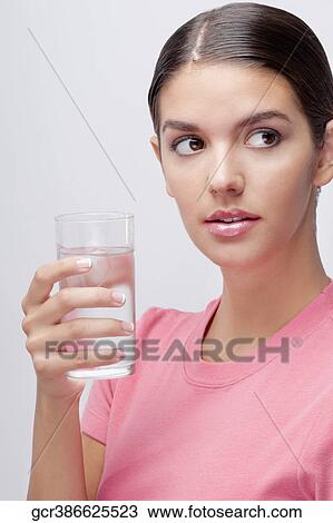 Close-up of a woman holding a glass of water View Large Photo Image Stock Image - Close-up of a woman holding a glass of water. Fotosearch