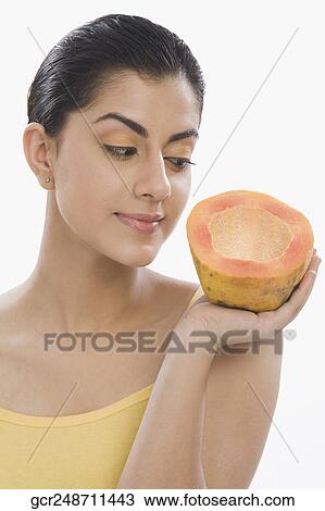 Close-up of a woman holding a half of papaya View Large Photo Image Stock Image - Close-up of a woman holding a half of papaya. Fotosearch