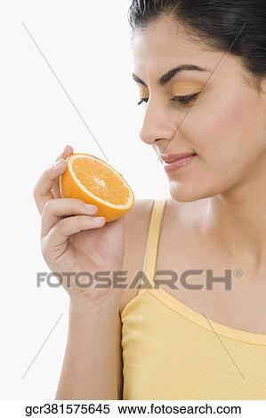 Close-up of a woman holding a half of orange View Large Photo Image Stock Photography - Close-up of a woman holding a half of orange. Fotosearch