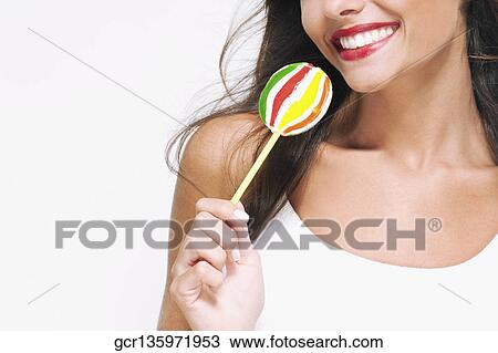 Close-up of a woman holding a lollipop View Large Photo Image Stock Image - Close-up of a woman holding a lollipop. Fotosearch