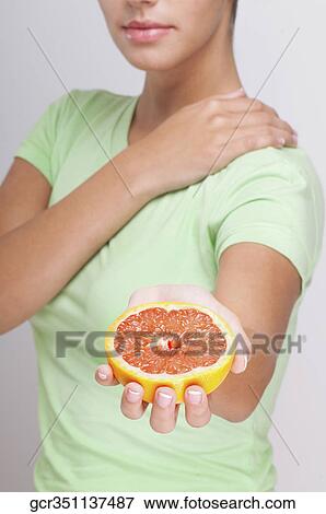Close-up of a woman holding a grapefruit View Large Photo Image Stock Photo - Close-up of a woman holding a grapefruit . Fotosearch