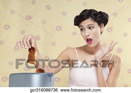 Close-up of a woman looking at a burnt toast View Large Photo Image Stock Photograph - Close-up of a woman looking at a burnt toast. Fotosearch