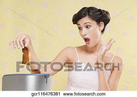 Close-up of a woman looking at burnt toast View Large Photo Image Stock Image - Close-up of a woman looking at burnt toast. Fotosearch