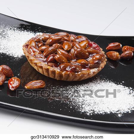 Stock Photo - Close-up of an almond tart served on a tray. Fotosearch