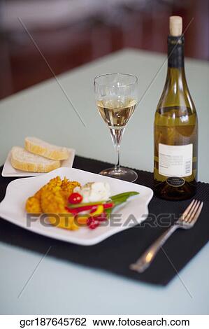 Stock Image - Close-up of batter fried chicken with a wine bottle. Fotosearch