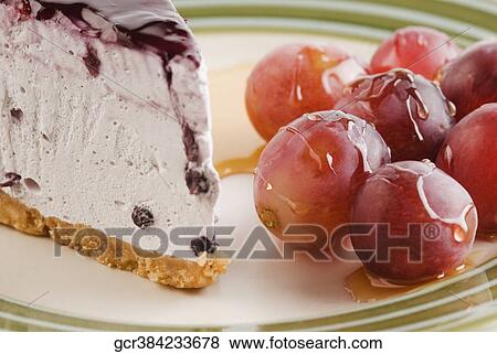 Stock Photo - Close-up of blueberry cheesecake with glazed grapes. Fotosearch
