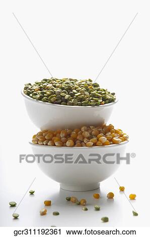 Stock Image - Close-up of bowls of green lentils and corn kernels. Fotosearch