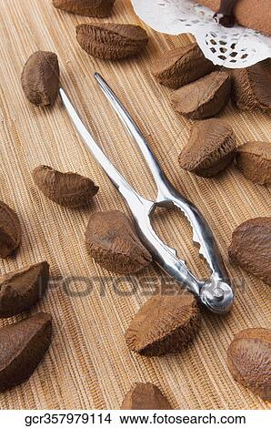 Picture - Close-up of brazil nuts with a nutcracker. Fotosearch