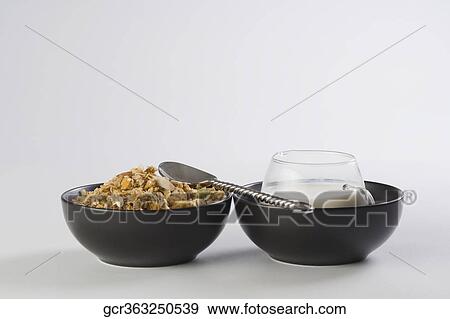 Close-up of breakfast cereal with a cup of milk View Large Photo Image Stock Photo - Close-up of breakfast cereal with a cup of milk. Fotosearch