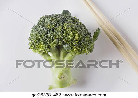 Stock Image - Close-up of broccoli with chopsticks. Fotosearch