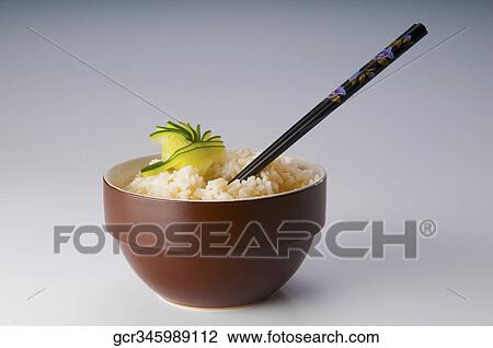 Close-up of chopsticks in a bowl of cooked brown rice View Large Photo Image Stock Image - Close-up of chopsticks in a bowl of cooked brown rice. Fotosearch