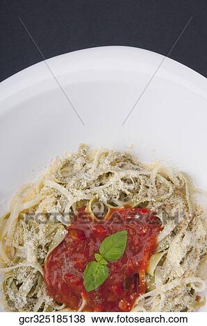Close-up of fettuccine topped with tomato sauce and basil leaves View Large Photo Image Stock Photo - Close-up of fettuccine topped with tomato sauce and basil leaves. Fotosearch