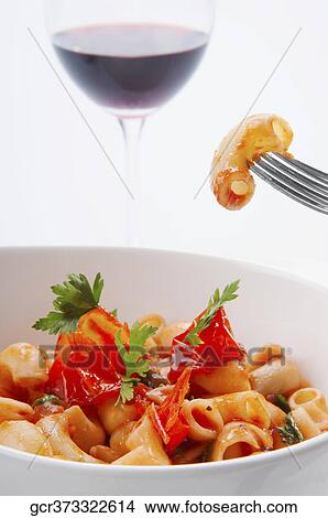 Close-up of macaroni in tomato sauce with a glass of red wine View Large Photo Image Picture - Close-up of macaroni in tomato sauce with a glass of red wine. Fotosearch